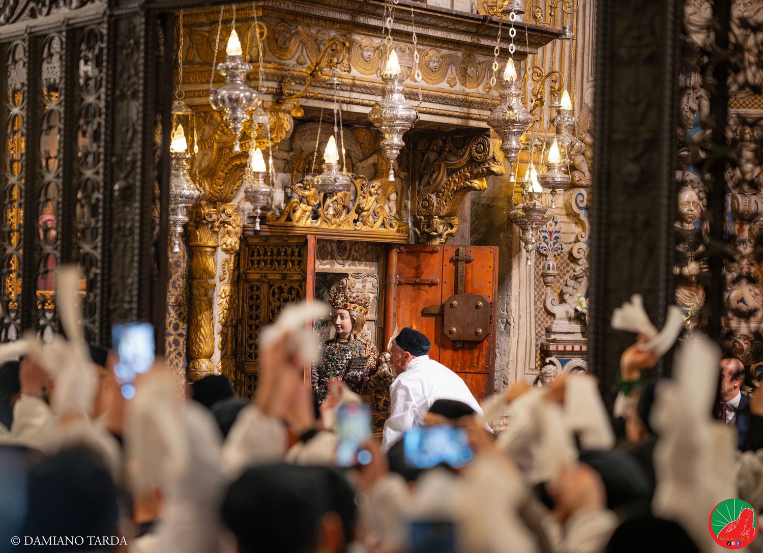 Devoti in sacco bianco agitano i fazzoletti nella Cattedrale di Catania all'uscita di Sant'Agata.