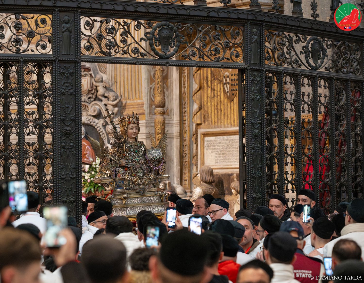 I fedeli fotografano il Busto di Sant'Agata oltre la cancellata della cappella in Cattedrale.