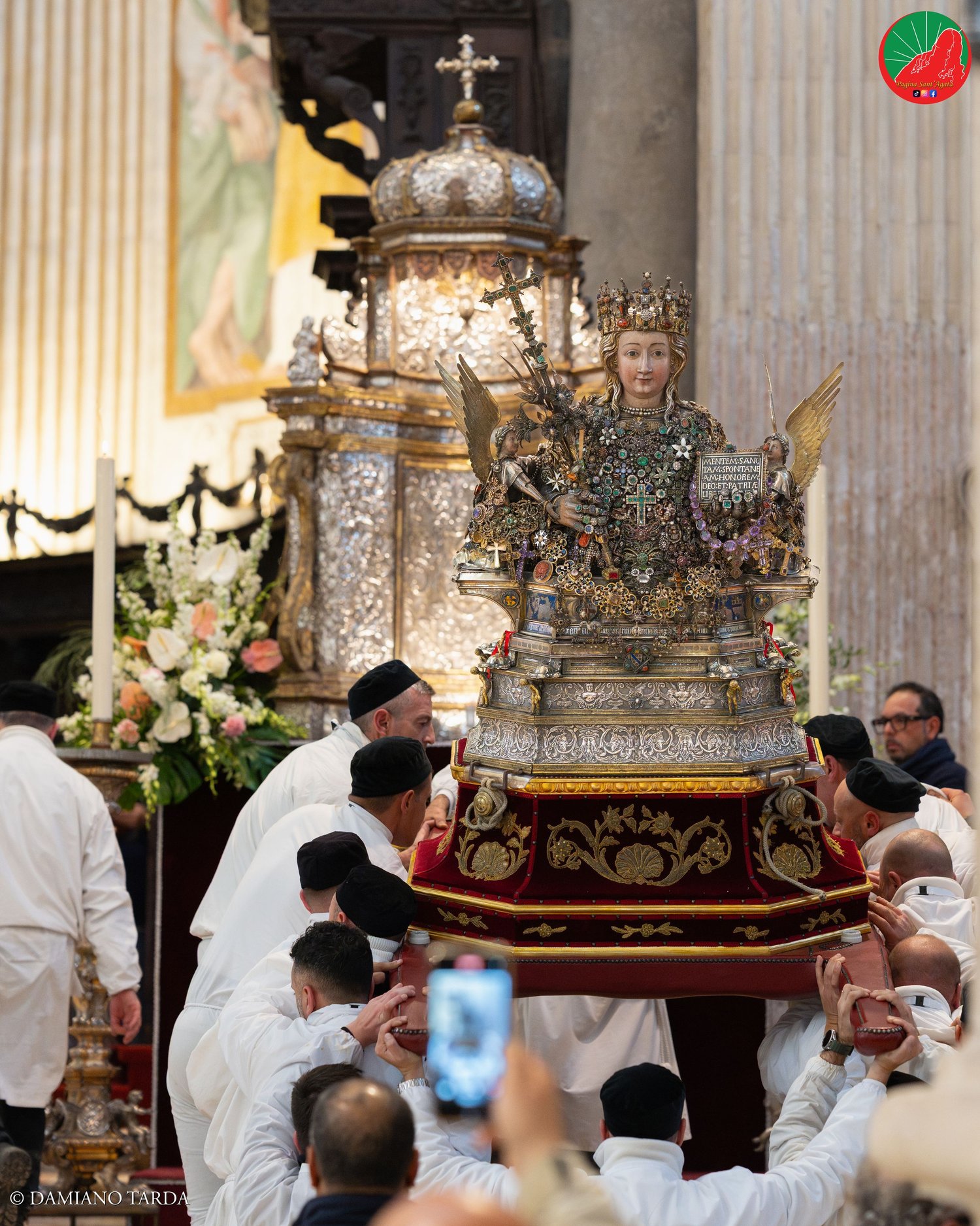 Il Busto di Sant'Agata portato a spalla dai devoti nella Cattedrale, tra fiori e candele.