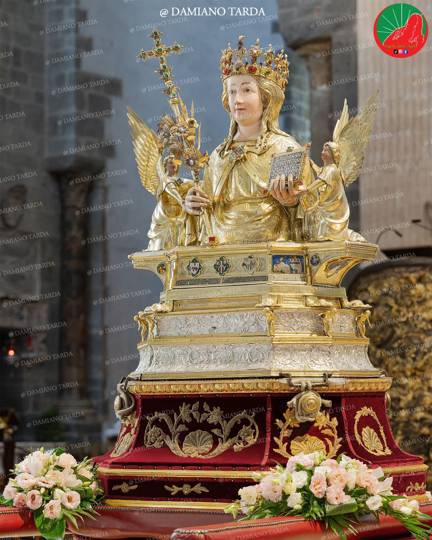 Il Busto reliquiario di Sant'Agata dopo il restauro, privo di gioielli ed ex voto, tra i fiori bianchi.
