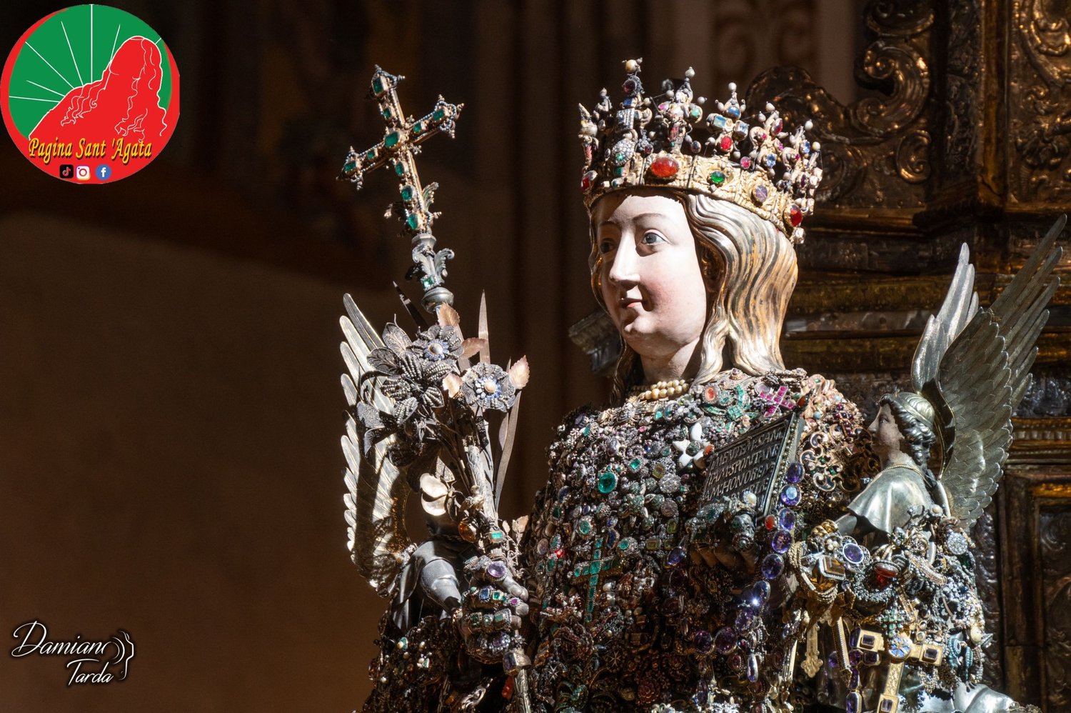Il Busto reliquiario di Sant'Agata su fondo scuro, con la corona e la croce gemmata.