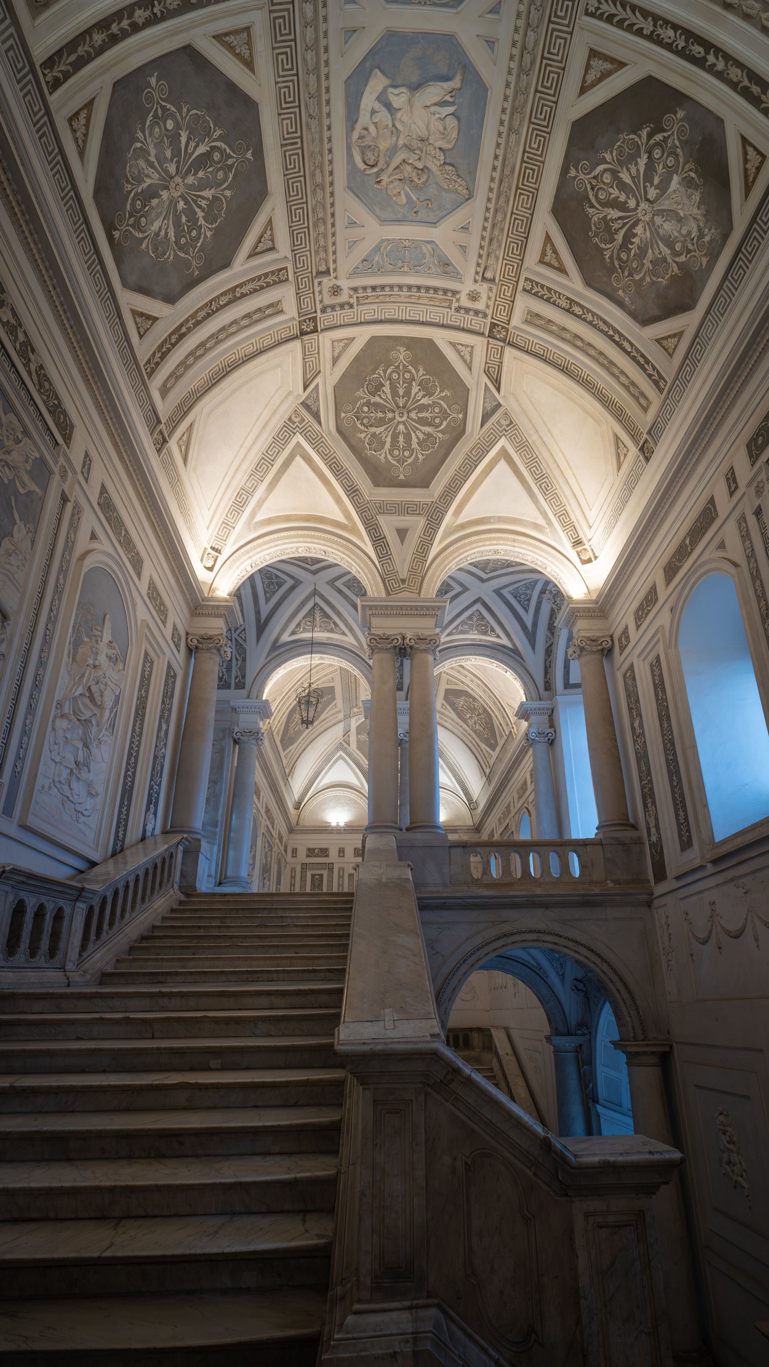 Scala barocca illuminata, monastero dei Benedettini, Catania, interno di palazzo storico, fotografia d’arte architettonica.