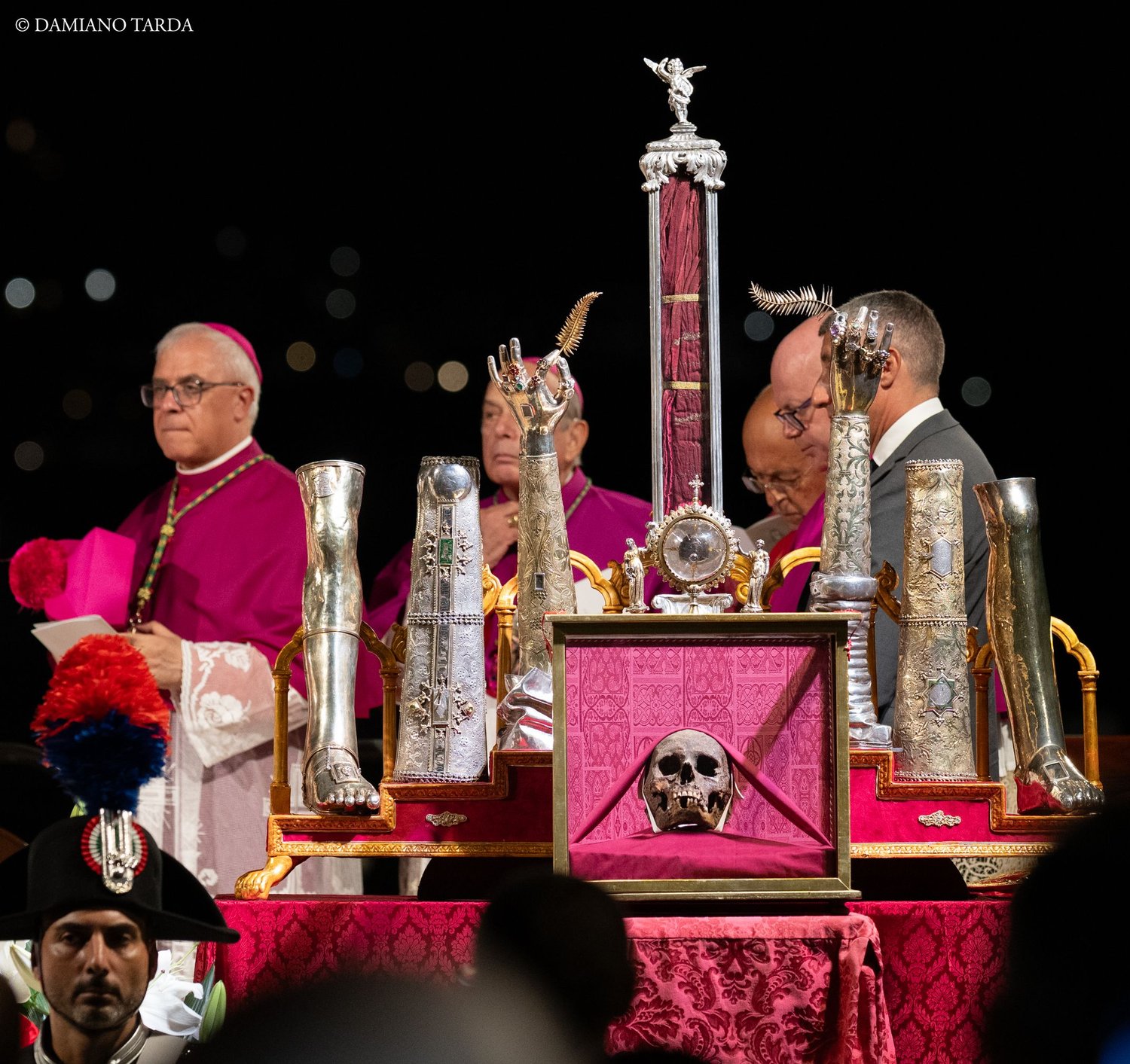 Un vescovo accanto ai reliquiari di Sant'Agata esposti sull'altare durante la celebrazione notturna.